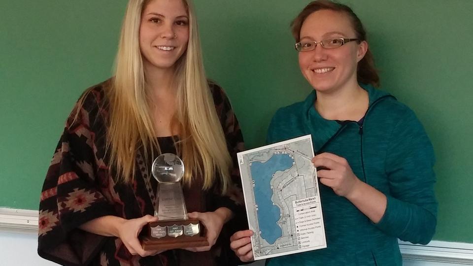 Student holding Carto Cup trophy with faculty member holding winning map