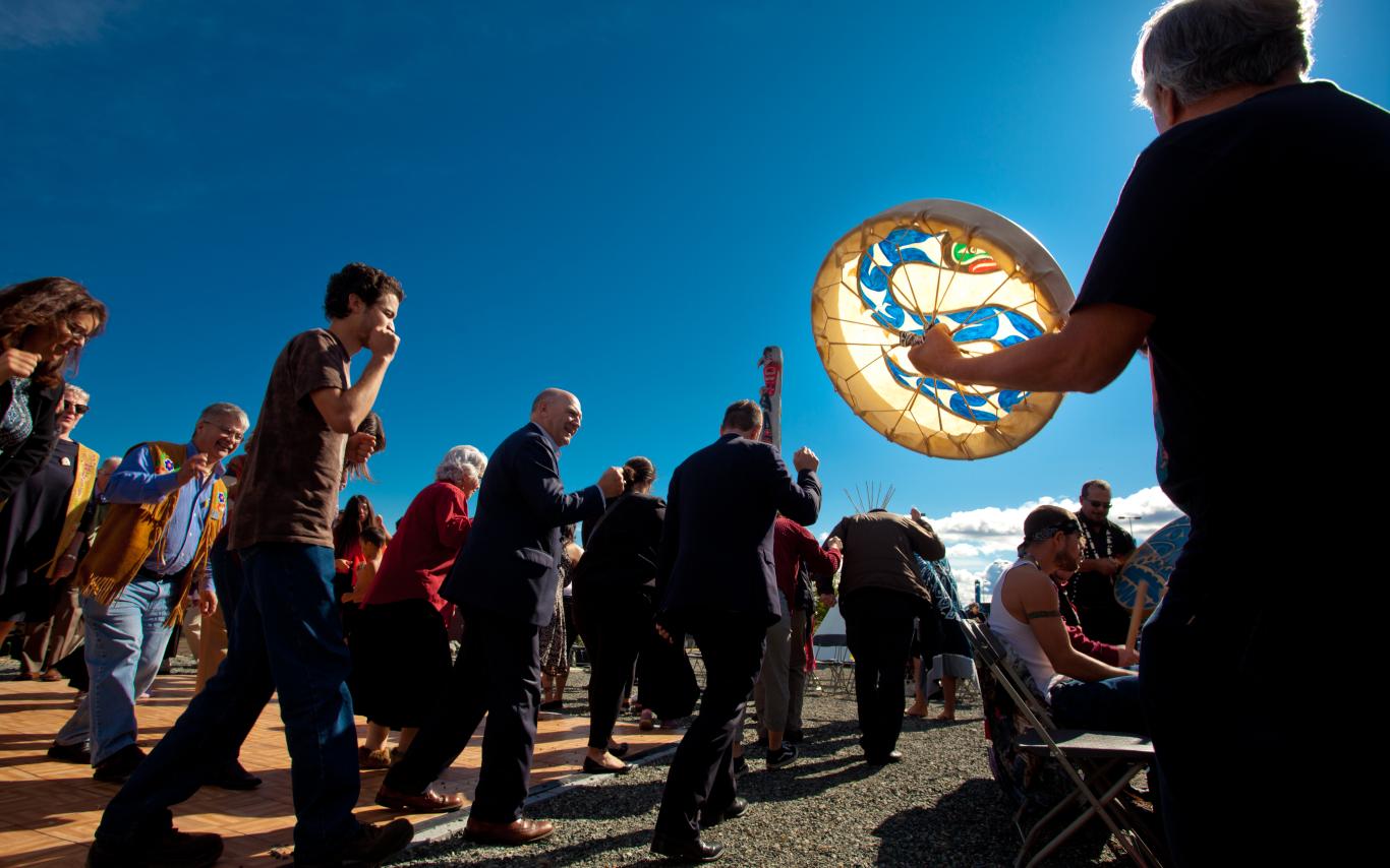 People walking in sun with drum