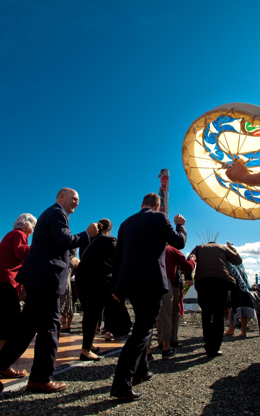 People walking in sun with drum